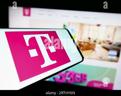 Téléphone portable avec logo de la société de télécommunications Deutsche Telekom AG sur l'écran devant le site Web. Concentrez-vous sur le centre de l'écran du téléphone. Banque D'Images