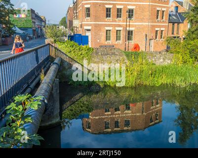 Femme marchant à travers Hythe Bridge, Castle Mill Stream, Oxford, Oxfordshire, Angleterre, ROYAUME-UNI, GB. Banque D'Images