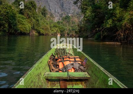 Bateau en bois avec gilets de sauvetage marron et orange, grotte de Konglor, Thakhek, Laos Banque D'Images