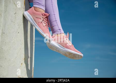 gros plan de baskets roses sur un fond de ciel bleu, concept de fitness Banque D'Images