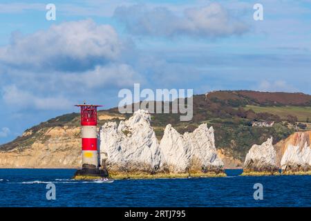 Le soleil du soir illumine le phare et les pierres empilées d'aiguilles à l'île de Wight, Hampshire Royaume-Uni en septembre Banque D'Images