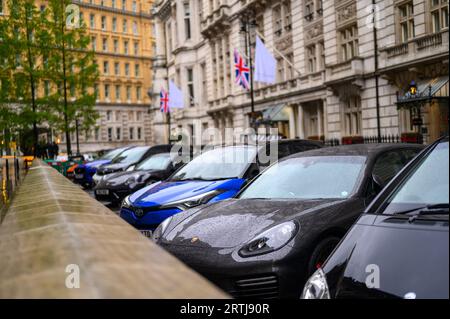 LONDRES - 24 avril 2023 : une rangée de voitures garées sur une ruelle pluvieuse de Londres, avec une faible profondeur de champ, capture l'essence de la vie urbaine en W humide Banque D'Images