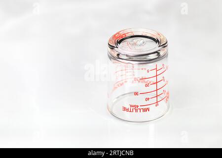 gobelet doseur en verre inversé ou gobelet doseur avec mesures en millilitres affichées. Banque D'Images