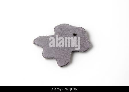 Un morceau de cuir fendu et nubuck en forme de symbole de cuir véritable. Étiquette de chaussure en cuir isolé sur fond blanc Banque D'Images