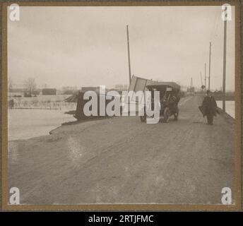 Janvier 1910, Archive photo de la Grande inondation de Paris, voiture et piéton sur une route au milieu de l'eau dans une banlieue de Paris, Banque D'Images