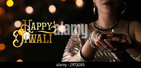 Longue bannière pour Happy Diwali avec une femme indienne tenant une bougie incandescente Banque D'Images