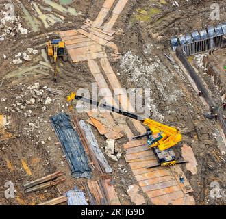 Pelle avec marteau hydraulique ou pelle rétro et grue industrielle lourde, travail de camion-grue sur le chantier de construction. Banque D'Images