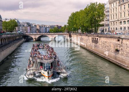 Paris, France - 10 août 2023 : bateau-mouche avec des touristes naviguant sur la Seine, en arrière-plan Pont Saint-Michel avec pari Napoléon symbole Banque D'Images