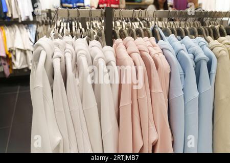 Les sweat-shirts pour femmes sont accrochés à des cintres dans un magasin de vêtements. Gros plan, arrière-plan. Banque D'Images