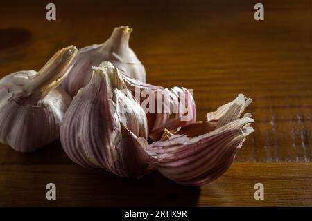 Goiania, Goias, Brésil – 24 mai 2023 : quelques têtes d’ail sur une table en bois avec une surface brillante. Banque D'Images