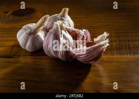 Goiania, Goias, Brésil – 24 mai 2023 : quelques têtes d’ail sur une table en bois avec une surface brillante. Banque D'Images