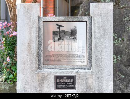 nagasaki, kyushu - décembre 11 2022 : panneau expliquant en anglais et en japonais l'histoire de l'arc torii du sanctuaire Sanno Shinto endommagé par l'atomi Banque D'Images