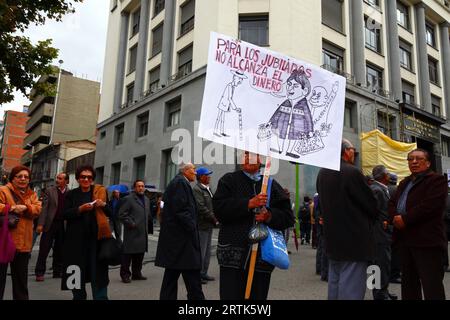 Des enseignants retraités tiennent une caricature du président bolivien Evo Morales Ayma tenant des sacs d'argent liquide à un barrage routier dans le centre-ville lors d'une manifestation réclamant une augmentation de leurs paiements de pension, la Paz, Bolivie. Banque D'Images