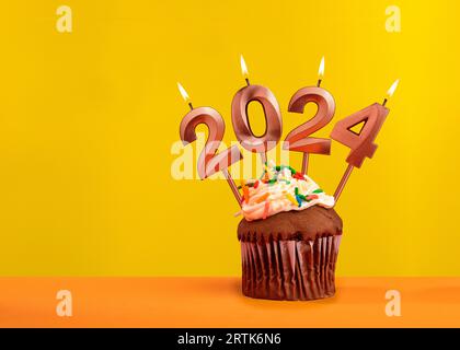 Bougies numéro 2024 pour bonne année - célébration de la veille du nouvel an sur fond jaune Banque D'Images