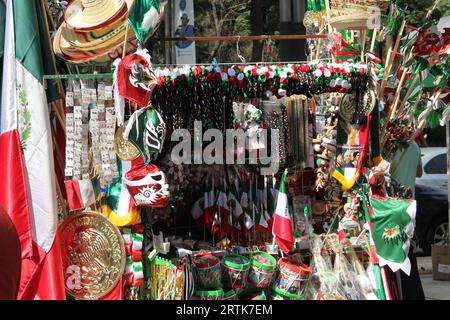 Mexico, Mexique - 6 septembre 2023 : Stall de rue vendant des drapeaux tricolores mexicains, des roues d'épingle, des chapeaux et d'autres articles nationaux Banque D'Images