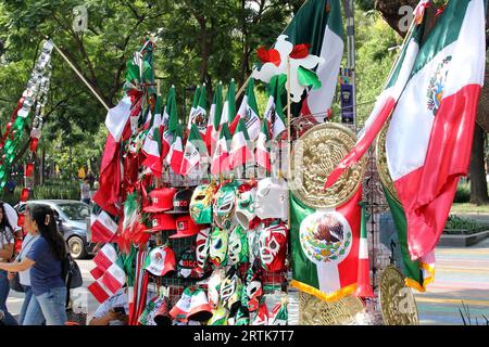 Mexico, Mexique - 6 septembre 2023 : Stall de rue vendant des drapeaux tricolores mexicains, des roues d'épingle, des chapeaux et d'autres articles nationaux Banque D'Images