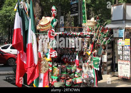 Mexico, Mexique - 6 septembre 2023 : Stall de rue vendant des drapeaux tricolores mexicains, des roues d'épingle, des chapeaux et d'autres articles nationaux Banque D'Images