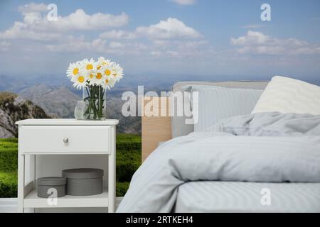 Intérieur de la chambre avec lit confortable et papiers peints de paysage de montagne Banque D'Images