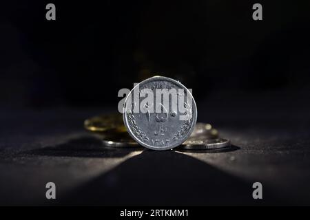 Image d'une pièce iranienne sur fond noir, avec un focus sur une pièce de 250 rians. Le rial est la monnaie officielle de l'Iran. Il est subdivisé int Banque D'Images