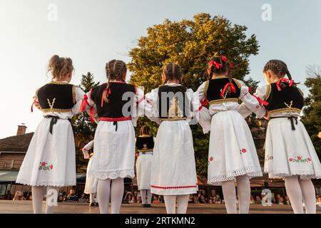 Photo d'un groupe d'enfants, d'enfants, de gens dansant un kolo serbe dans le village de Pecinci, en Serbie. Kolo est une danse circulaire slave du Sud, trouvé uedn Banque D'Images