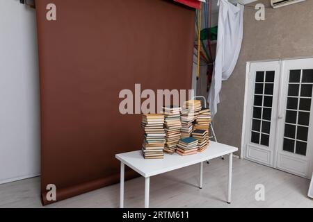 beaucoup de livres sur la table dans la salle avec un fond brun Banque D'Images