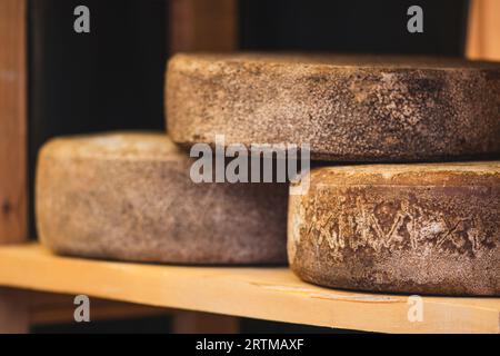 Roues de fromage assaisonné bio naturel maison sur des étagères en bois, gros plan Banque D'Images