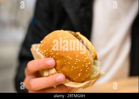 Ivano-Frankivsk, Ukraine, June 7, 2023: a little boy eats a royal cheeseburger at McDonald's. Stock Photo