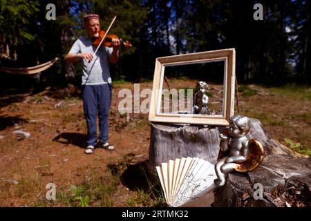 Promenade musicale en forêt sur le thème du baroque. Violoniste. Cordon. France. Banque D'Images