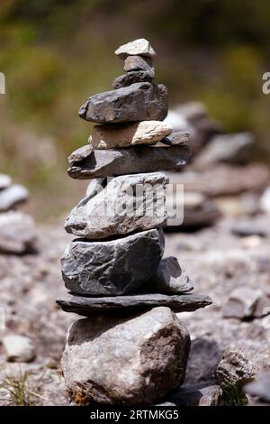 Gros plan sur cairn, pyramide lapidée, panneau de mémoire touristique sur le chemin de montagne. Banque D'Images