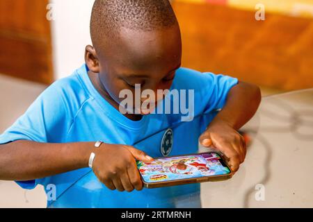 Garçon jouant avec un téléphone portable à Dakar, Sénégal Banque D'Images