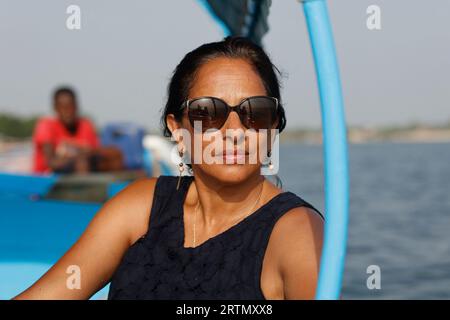 Femme sur un bateau naviguant dans le delta du fleuve Saloum, Sénégal Banque D'Images