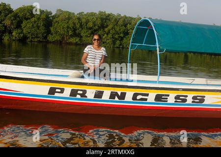 Femme sur un bateau dans le delta du fleuve Saloum, Sénégal Banque D'Images