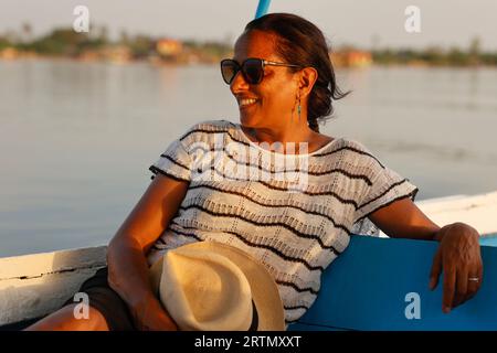 Femme sur un bateau naviguant dans le delta du fleuve Saloum, Sénégal Banque D'Images