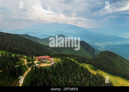 Vue aérienne drone de Poiana Brasov, Roumanie. Bâtiments touristiques situés au sommet de la montagne couverte de forêt luxuriante Banque D'Images