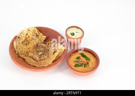 Riz indien sélectif concentré dosa et chutney de tomates, chutney de noix de coco avec assiette de boue servis de manière traditionnelle. Vue de dessus de la nourriture de petit déjeuner de légumes indiens Banque D'Images