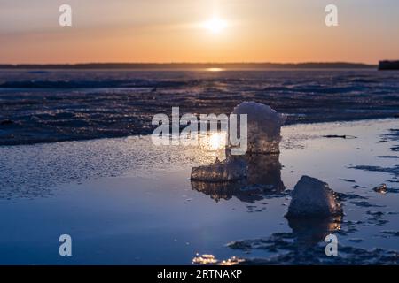 Paysage d'hiver avec lac gelé. Les glaçons reposent au soleil sur un coucher de soleil, photo naturelle en gros plan Banque D'Images