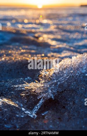 Paysage d'hiver avec eau de lac gelée. Cristaux de glace en plein soleil, photo verticale rapprochée avec flou sélectif Banque D'Images