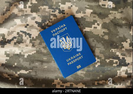 Passeport étranger civil ukrainien sur fond de pixel de camouflage militaire. Contrôle aux frontières Banque D'Images