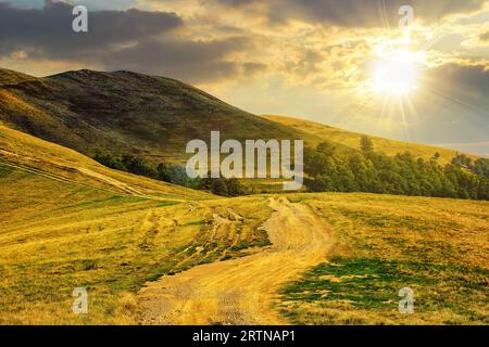 paysage de montagne de début d'automne avec chemin à travers la colline au coucher du soleil. beau paysage de campagne dans la lumière du soir Banque D'Images