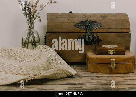 Vieilles boîtes en bois, un vase de fleurs sauvages sèches sur une vieille table. Nature morte rustique Banque D'Images