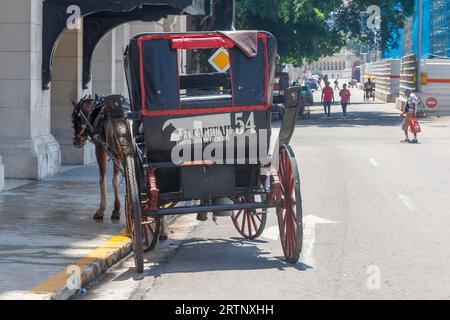 La Havane, Cuba - 30 août 2023 : une calèche est garée dans une rue de la vieille ville. Un chantier de construction en arrière-plan. Banque D'Images