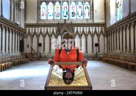 Visiteur touristique regardant dans un miroir pour voir le plafond de la Maison du Chapitre, Cathédrale de Canterbury, Kent Banque D'Images