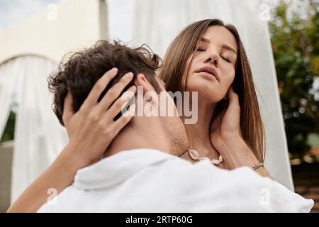 portrait d'homme embrassant le cou de belle femme lors d'une escapade romantique en été, geste d'amour Banque D'Images