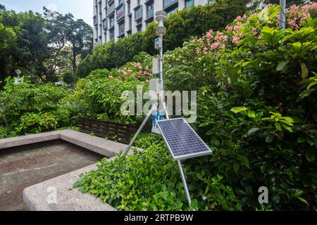 Une station météorologique placée à l'extérieur d'un parc public pour mesurer le débit d'air, la température, l'humidité, le rayonnement solaire et la concentration de polluants atmosphériques. Banque D'Images