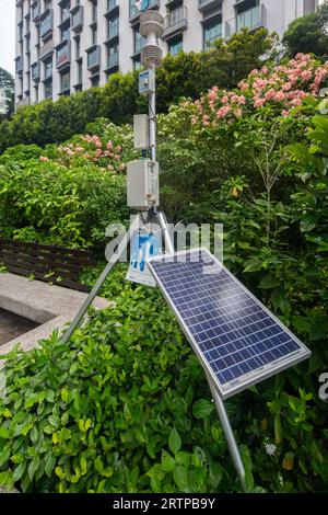 Une station météorologique placée à l'extérieur d'un parc public pour mesurer le débit d'air, la température, l'humidité, le rayonnement solaire et la concentration de polluants atmosphériques. Banque D'Images