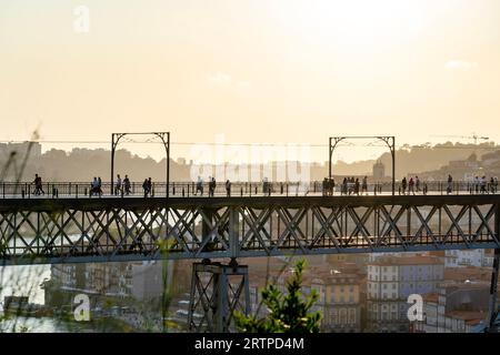 06.22.2023. Porto, Portugal : dom luiz brige à Porto sur le bord de la rivière Duero paysage urbain au coucher du soleil d'en haut avec les touristes Banque D'Images