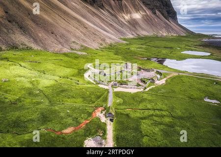 Vue aérienne du village viking rustique abandonné avec la montagne Vestrahorn sur la nature sauvage en été à la péninsule de Stokksnes, Islande Banque D'Images