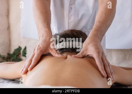 Femme couchée et ayant massage du dos au spa. Style de vie sain et concept de relaxation Banque D'Images