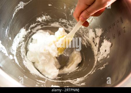 protéine fouettée. Ramasser une spatule avec meringue sur le fond du bol de cuisine Banque D'Images