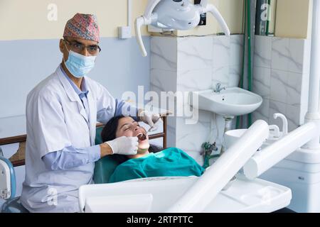 Katmandou, Népal - 02 septembre 2023 : Un dentiste népalais soignant son patient dans un hôpital dentaire Banque D'Images